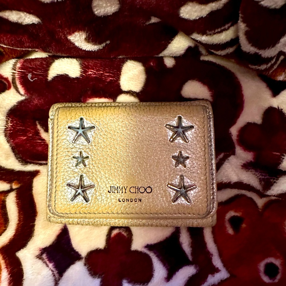 Jimmy choo wallet with stars and metallic coloring.